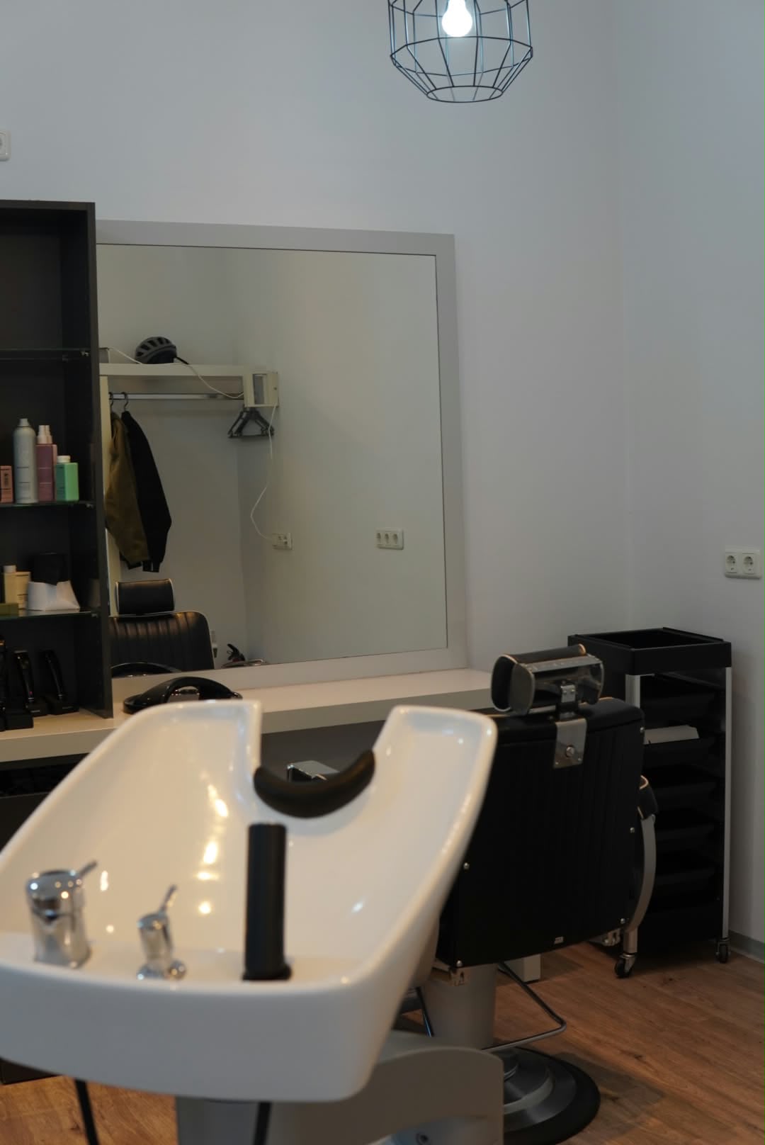 Zwei Stylingplätze mit großen Spiegeln und schwarzen Friseurstühlen